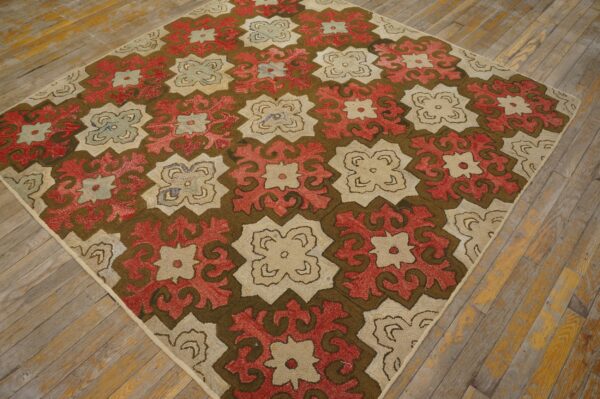 This textured rug features large, interlocking geometric medallions in dark brown, red, and beige on distressed wood planks.