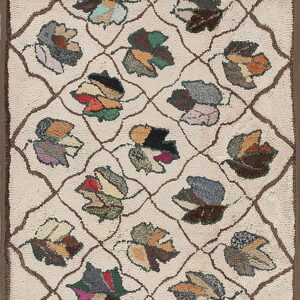 Cream rug with a brown trellis pattern surrounding multicolored, hooked-texture patchwork leaf motifs.