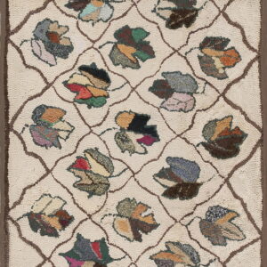 Textured cream rug with a brown geometric trellis and colorful, stylized patchwork leaf designs.