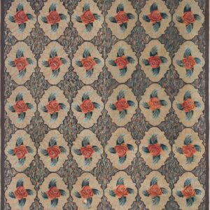 Golden floral rug with orange roses, green leaves, and calibration cards resting on light wooden flooring.