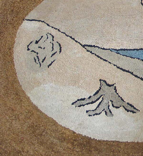 Textured rug detail with a light oval featuring abstract blue and gray nature motifs on a dark tan ground.
