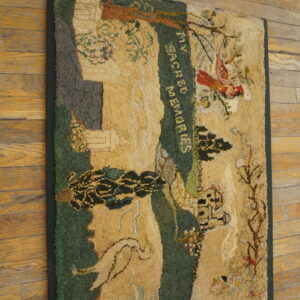 Highly textured gold, green, and red pictorial hooked rug lies diagonally across distressed wood flooring.