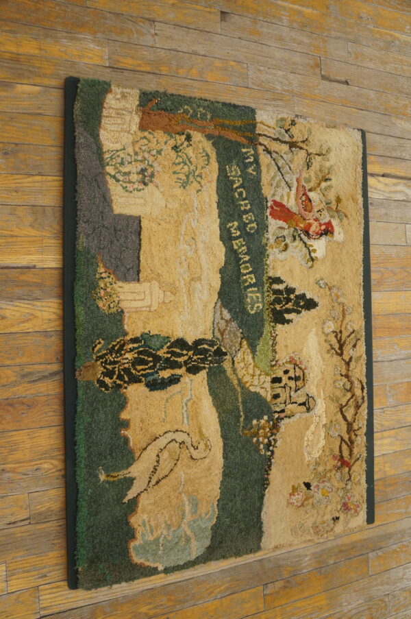 Highly textured gold, green, and red pictorial hooked rug lies diagonally across distressed wood flooring.