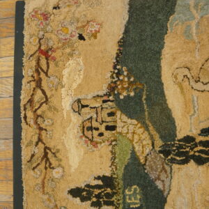 High-pile rug with a beige and dark green scenic pattern including the word MEMORIES on worn wood flooring.