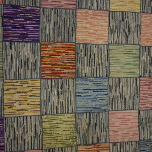 Textured, checkerboard rug using colorful horizontal squares and alternating vertical blocks of gray and black loops on a wood floor.