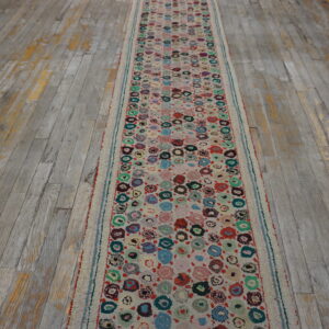A high-pile runner with colorful circular patterns rests on distressed gray wood plank flooring.