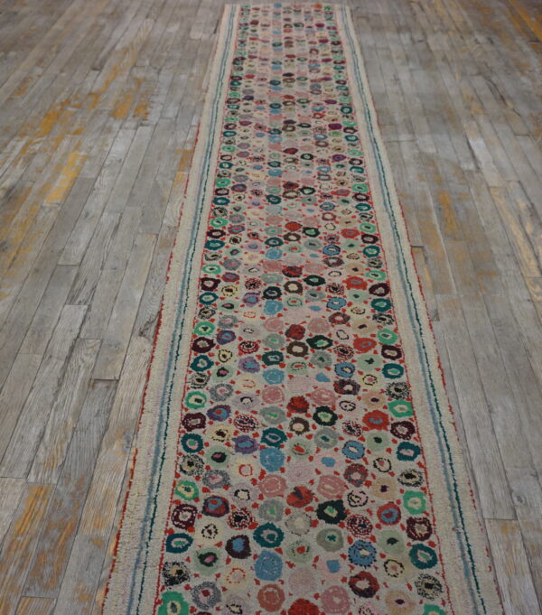 A high-pile runner with colorful circular patterns rests on distressed gray wood plank flooring.