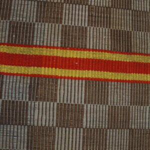 Woven rug with brown and beige vertical striped blocks, accented by horizontal red and yellow bands.