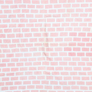 A wrinkled textile featuring a pink and white pattern that mimics a brick wall design.