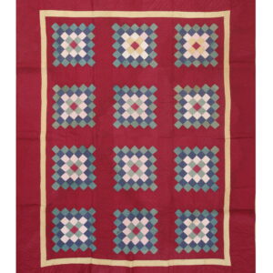 Red square textile featuring twelve multi-color diamond patterns in blue, teal, white, and yellow with a cream border.