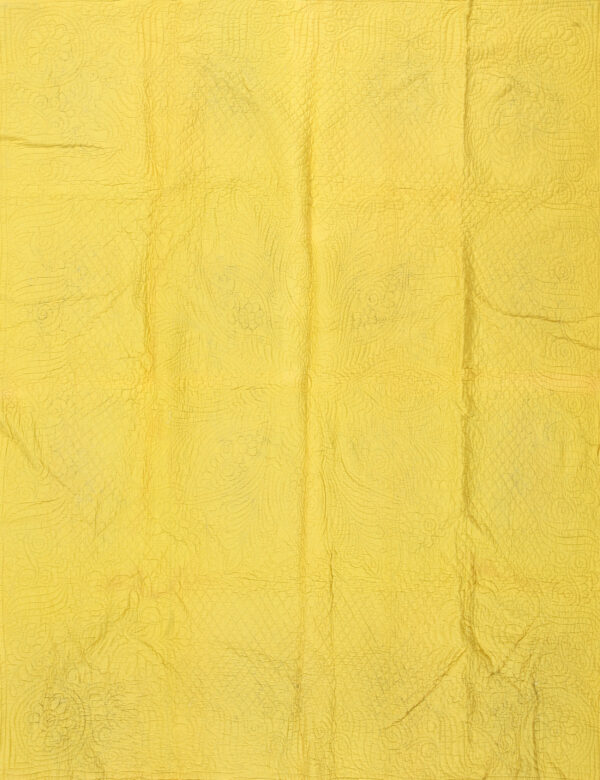 Quilt america antique knotted wool 1920s multicolor small scatter size rug 1 Bright yellow quilted textile featuring floral stitching is folded back to reveal a contrasting aqua reverse side.