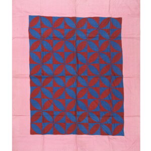 Geometric textile featuring a dense interlocking red and blue petal pattern with a wide pink edge.