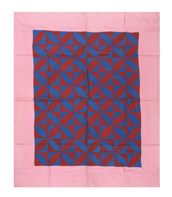 Geometric textile featuring a dense interlocking red and blue petal pattern with a wide pink edge.