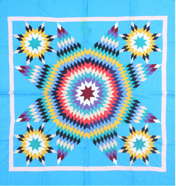 Blue textile with a radiating central star pattern in red, yellow, purple, teal, and black diamonds.