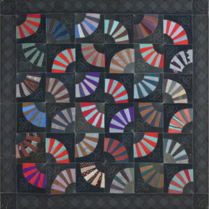 A dark textile featuring a grid of multicolored fan patchwork patterns with white decorative stitching.