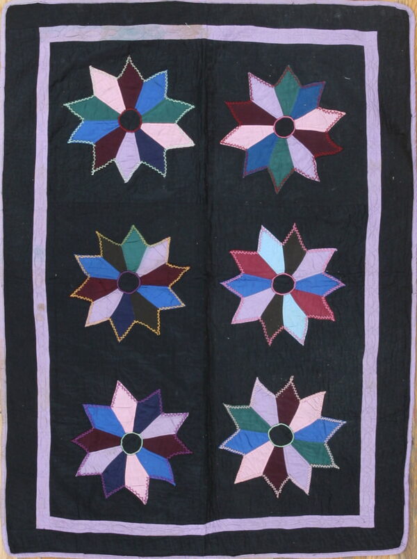 Dark rug with six large colorful star appliqués featuring a lavender border and zigzag stitching details.