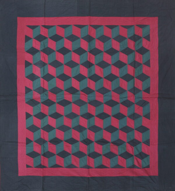 Flat textile rug featuring a red, green, and black geometric tumbling block pattern with dark borders.