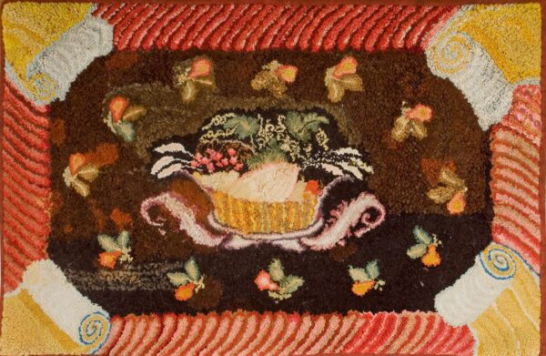 Textured high-pile rug with a central dark medallion featuring a fruit basket and a diagonally striped red and gold border.