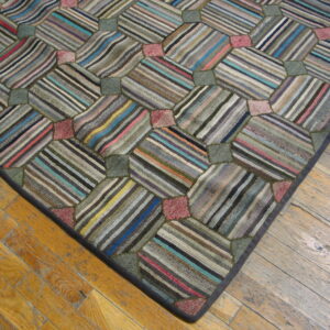 Geometric patchwork rug with multicolored striped panels and textured pile lies on light brown wood flooring.