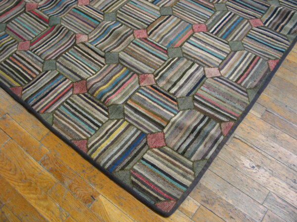 Geometric patchwork rug with multicolored striped panels and textured pile lies on light brown wood flooring.