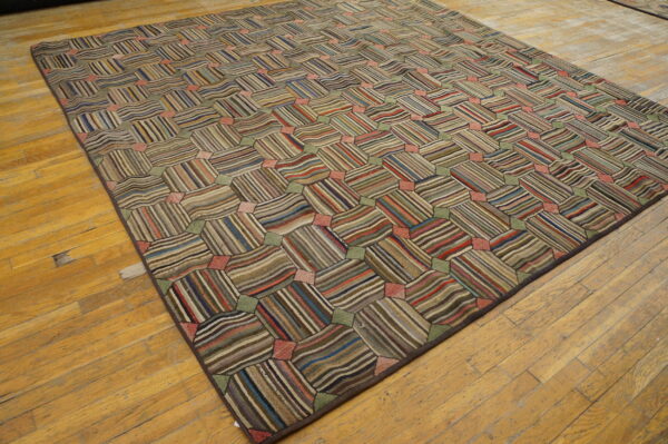 Multicolored rug with a tessellating striped block pattern displayed on distressed hardwood floors.