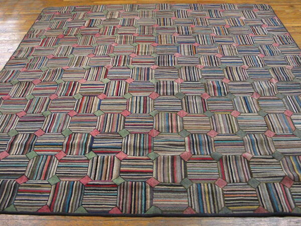 Multicolored striped geometric rug featuring repeating octagons linked by pink and green squares on a wood floor.