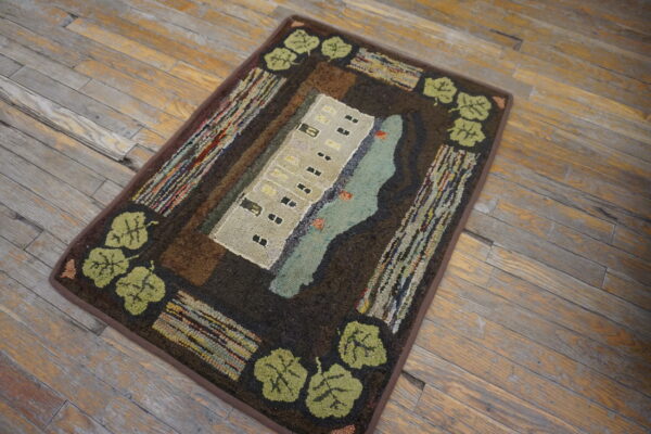 Textured folk art rug showing a beige building and aqua water surrounded by dark brown and green leaves.