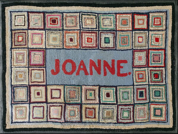 Hooked rug featuring multicolored concentric squares surrounding a blue center panel with the name joanne.