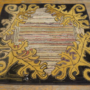 Yellow scrollwork frames a multicolored striped, textured center field on a dark border and plank wood floor.