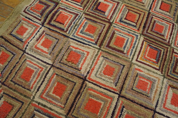 Textured rug displaying a geometric pattern of orange and multicolored concentric squares on wooden planks.