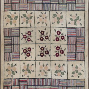 Hooked rug featuring an ivory checkerboard design with colorful striped blocks and stylized floral motifs.