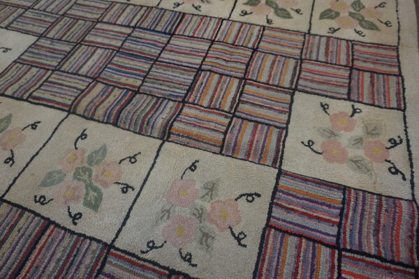 Shaggy rug with alternating blocks of multicolored vertical stripes and cream squares with flowers.