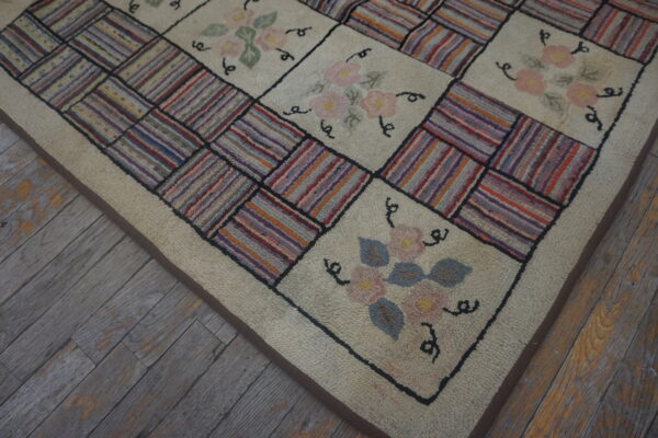 Textured patchwork rug featuring floral squares and striped multicolored block sections on weathered wood planks.
