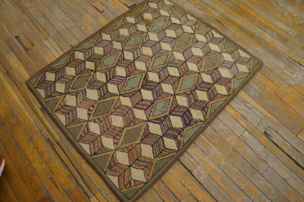 Multicolored striped and solid green geometric cube pattern rug sits upon rustic, worn wood planks.