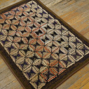A textured rug with a multicolored diamond lattice in cream, rust, and purple sits on distressed wood planks.