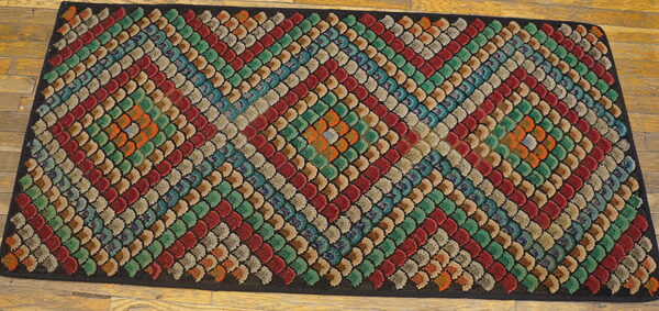 Multicolored rug with a textured scalloped pattern arranged in diagonal stripes on wood flooring.