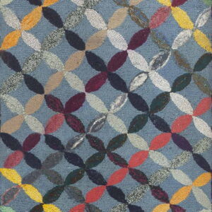 Hooked rug with an interlocking, multicolored geometric pattern over a blue loop pile field.
