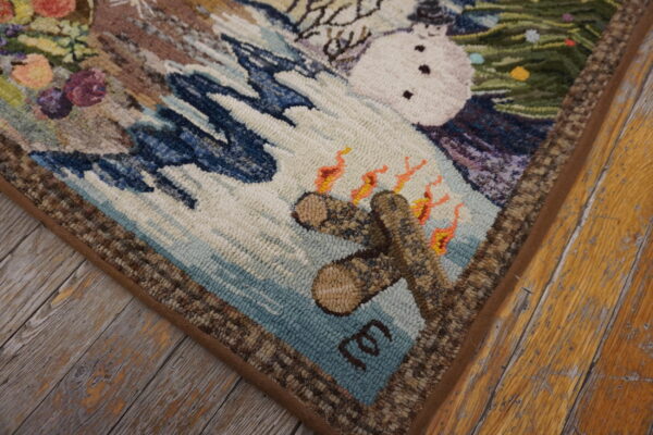 Textured, multi-colored hooked rug corner depicting a snowman, campfire, and winter scenery on rustic wood plank flooring.