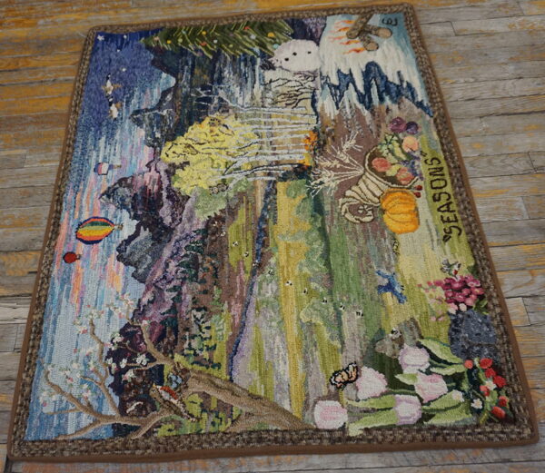 Multicolored hooked rug depicting a detailed seasonal landscape with waterfalls, flowers, and snow on weathered wood.