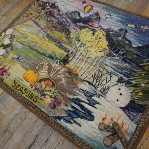 Textured multicolored pictorial rug depicting the four seasons rests on distressed gray and yellow wooden plank flooring.