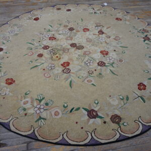 Light beige round rug featuring a multicolored floral pattern and a scalloped lavender border on distressed wood planks.