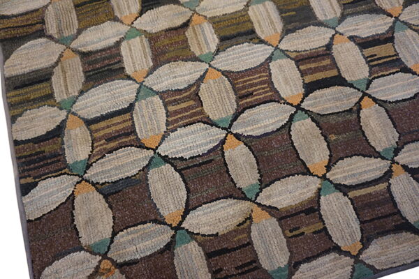 Textured rug with interlocking beige oval shapes and teal accents on a dark striped brown background.