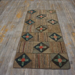 Multicolor textured runner rug with alternating striped and diamond floral squares sits on distressed wood flooring.