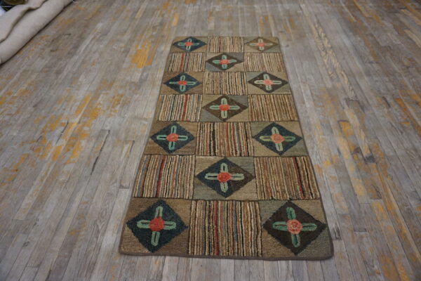 Multicolor textured runner rug with alternating striped and diamond floral squares sits on distressed wood flooring.