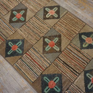 Textured runner rug in earthy tones, displaying alternating floral and striped blocks on gray distressed wood flooring.