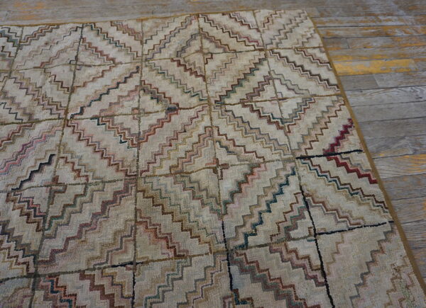Beige shaggy rug with multicolored zigzag lines creating a grid pattern on weathered wood flooring.