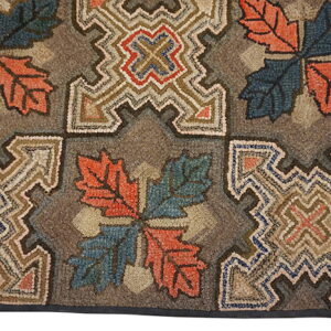 Coarse, hooked rug featuring rustic orange and blue leaf motifs alternating with complex tan geometric blocks.