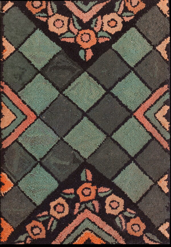 Teal and dark green diamond rug accented by coral and peach floral motifs on a black ground.