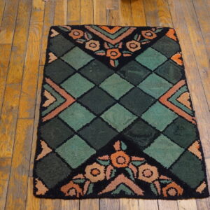 Small rug featuring a green diamond lattice and orange floral designs on distressed wood planks.