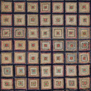 Low-pile rug with a grid of multicolored concentric squares sits on weathered gray wood flooring.